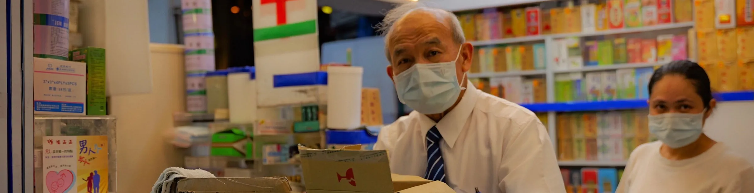 A pharmacist opening a delivery at the counter