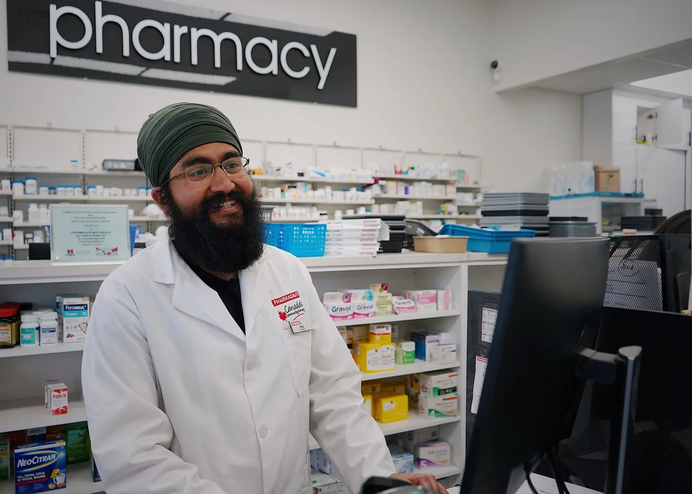 A pharmacist at the dispensary counter, working at the till