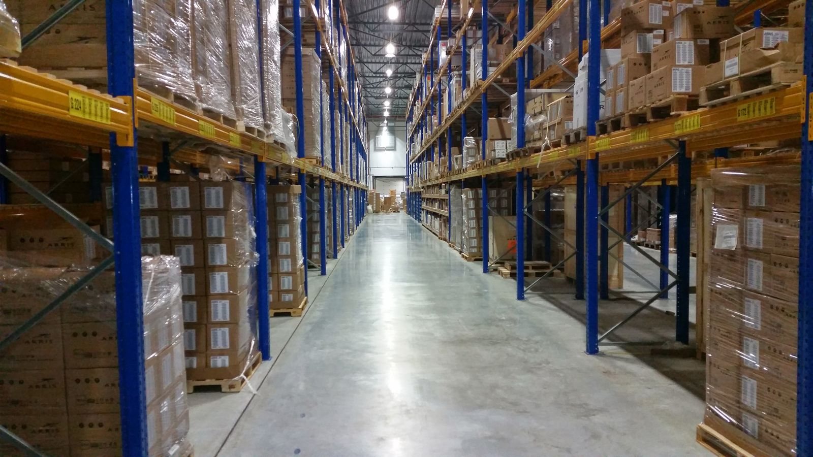 Warehouse aisle with pallets of boxed stock on racking